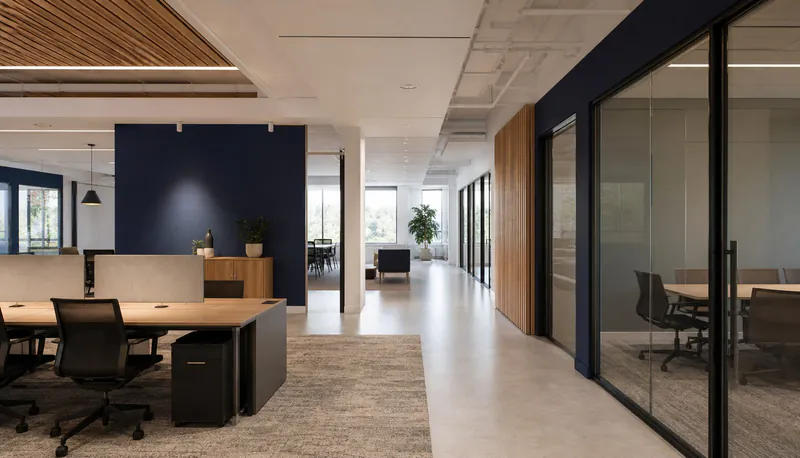 Illustrative corporate office with glass meeting rooms and a clear walkway.